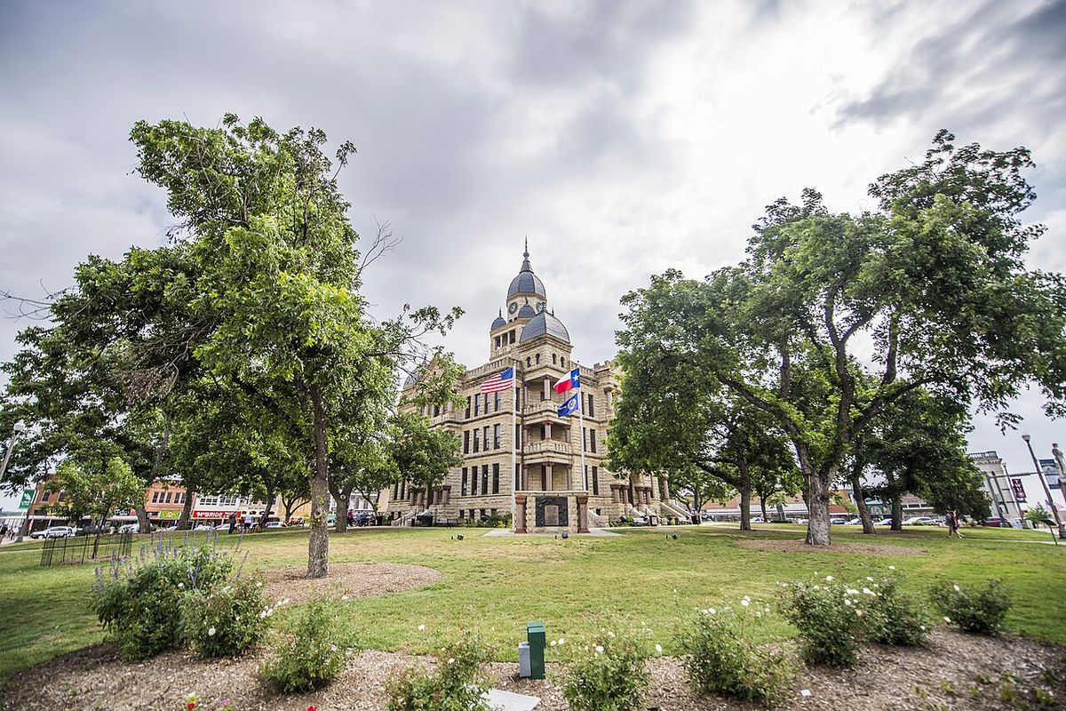 The Denton County Courthouse on the town square, framed by trees